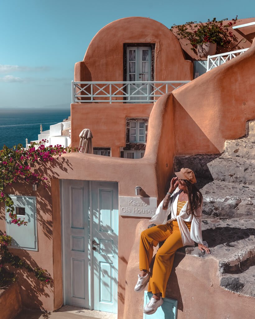 orange house with blue door in Oia