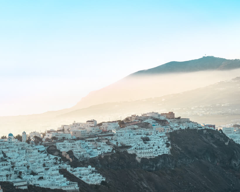 the sun rises over Santorini