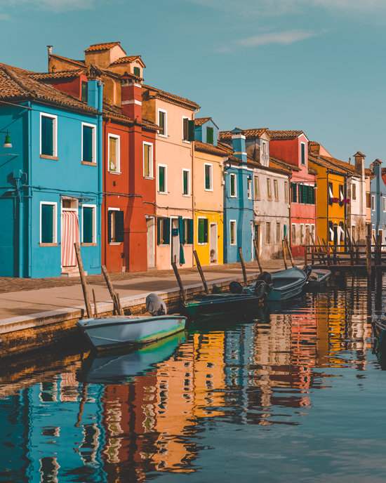 colorful houses in Burano reflected in the water canal