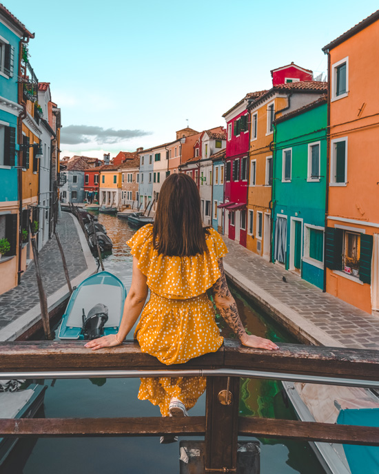 Women sit on a bridge in Burano Island
